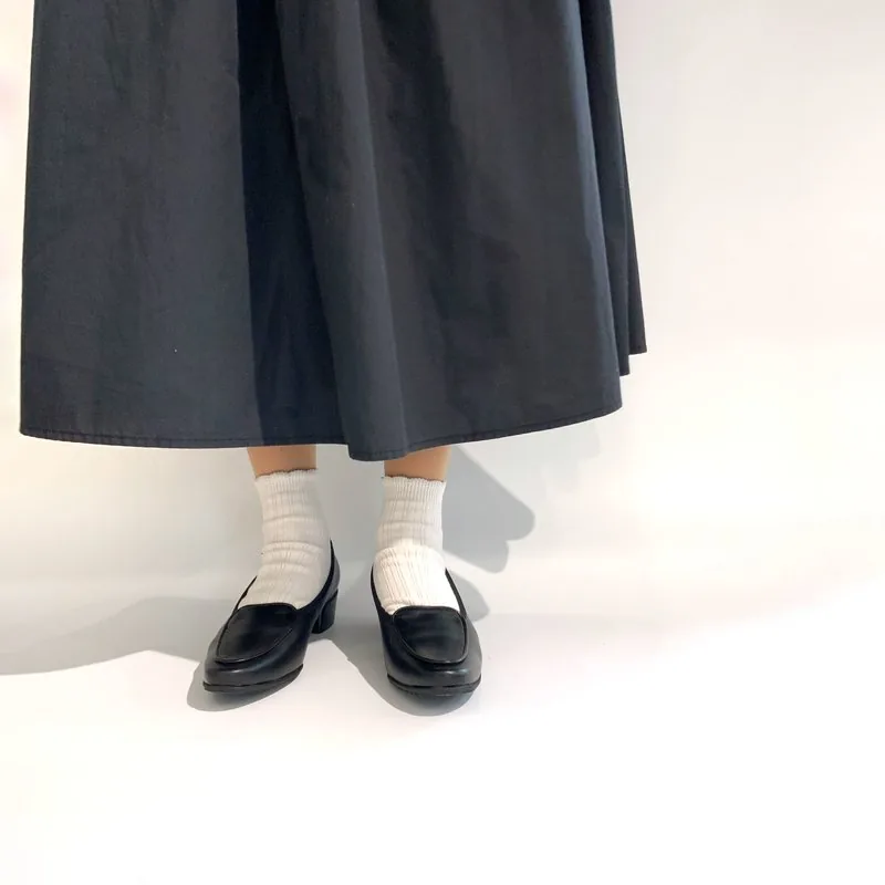 黒ローファーを履いた女性の足元